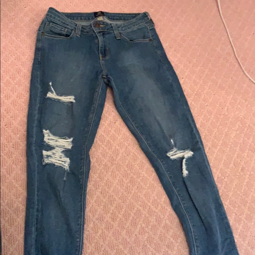 Trendy ripped jeans with unfinished frayed bottom.